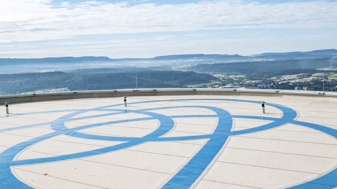 Eine Aussichtsplattform mit dem Thyssenkrupp Logo und einer weitläufigen Landschaft.